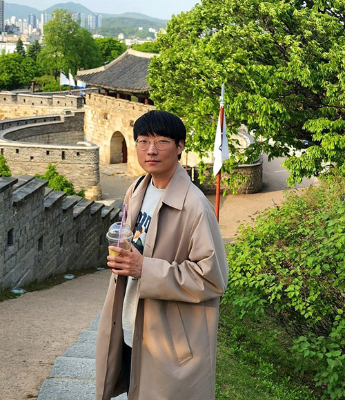 Hee Woong Park stands on a path and looks at the camera