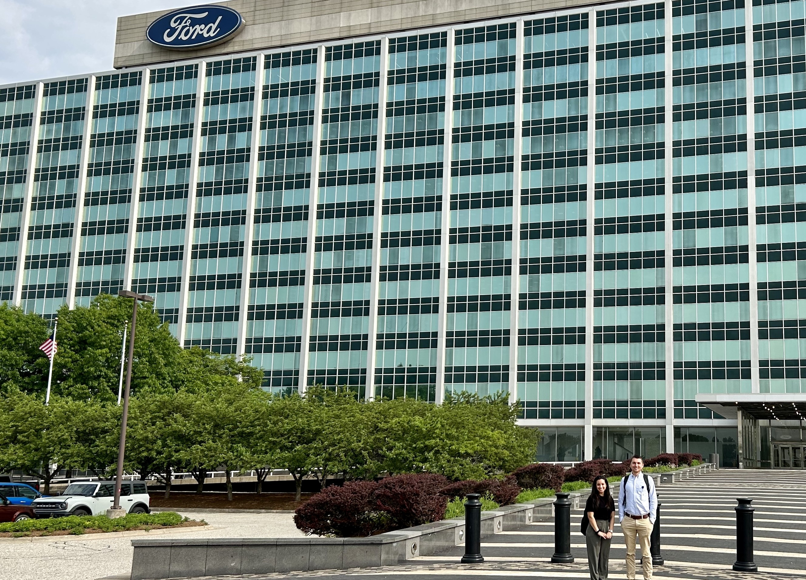 Grad student Connor Eichenauer stands in front of the Ford Motor Company's building. In the top left corner, Ford is visible on the building.