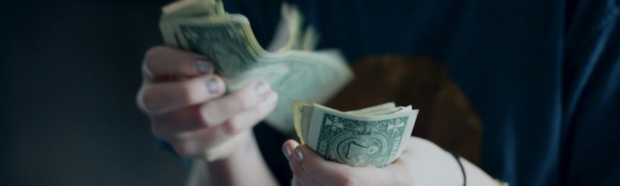 A close up of hands counting cash.