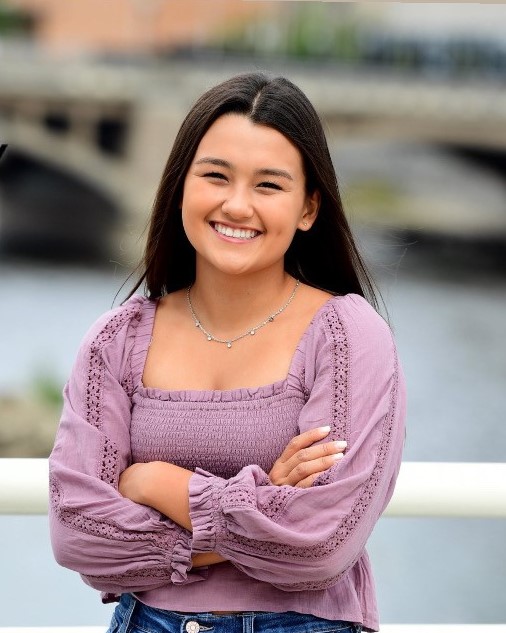 Isabelle McKinney smiles at the camera with her arms crossed.