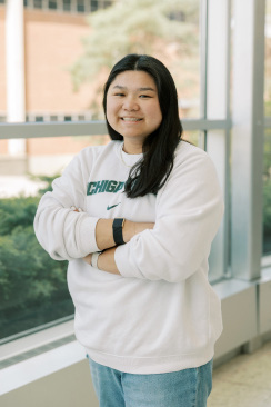 A photo of Lily Wenkel smiling at the camera while wearing an MSU sweatshirt.