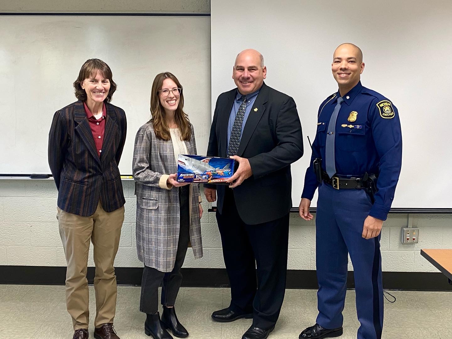 Winner Emily Gerkins receives her SharkTank trophy from the Michigan State Police representatives