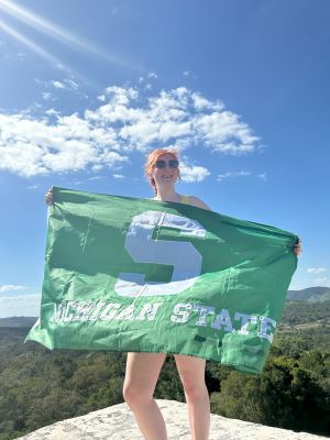 Taylor Robison with an MSU flag in Belize.jpg