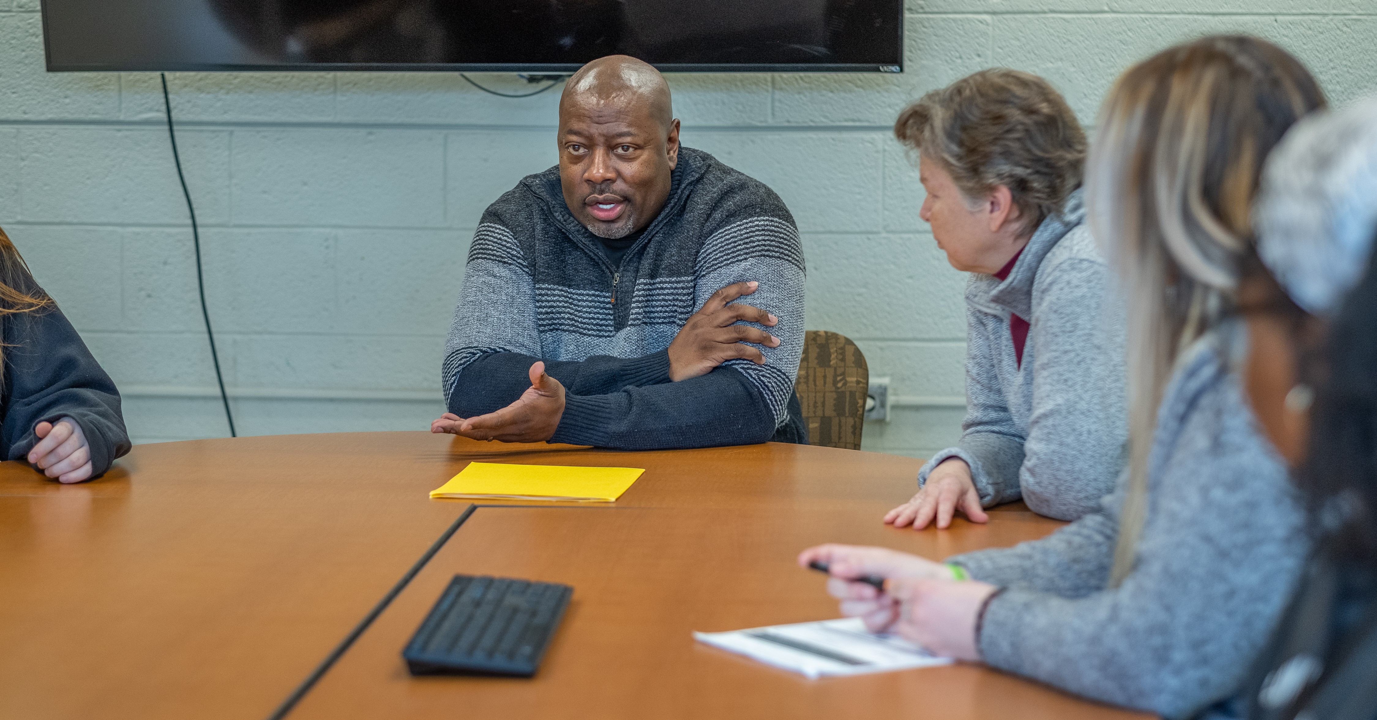 Sean Hankins and other program members talk at a table