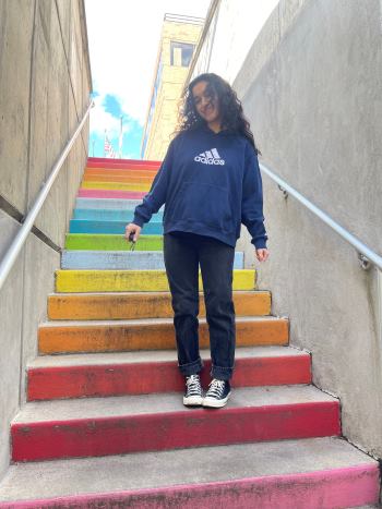 Albiona Beka stands on colorful steps and smiles at the camera.